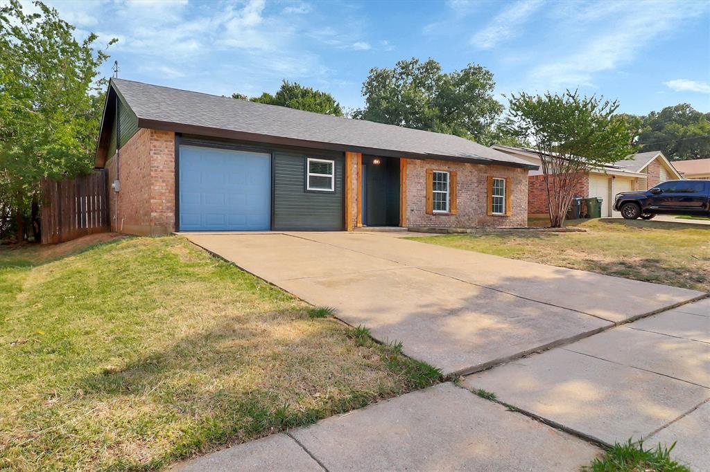 Single-story residence featuring a brick and horizontal siding exterior, attached garage, concrete driveway, and wood-framed window shutters