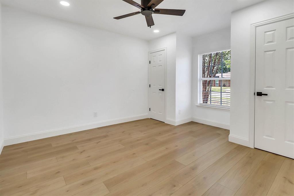 Wood-finish flooring, recessed lighting, matte black hardware, single-pane window, and a ceiling fan