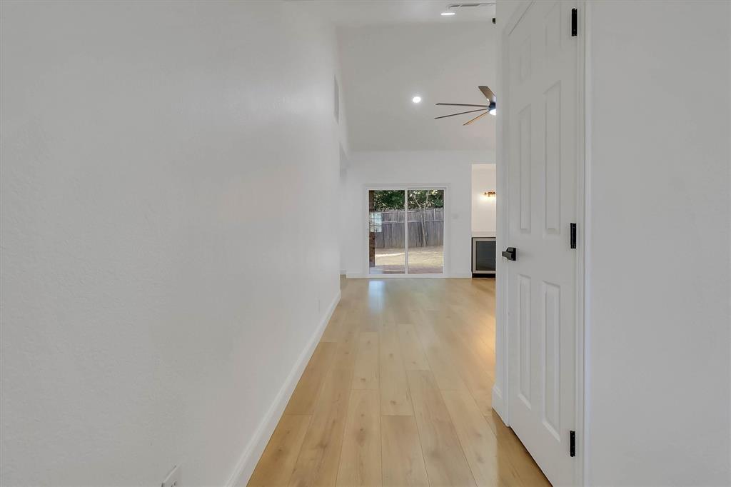 Vaulted ceilings, wood-finish flooring, recessed lighting, ceiling fan, and glass sliding patio doors