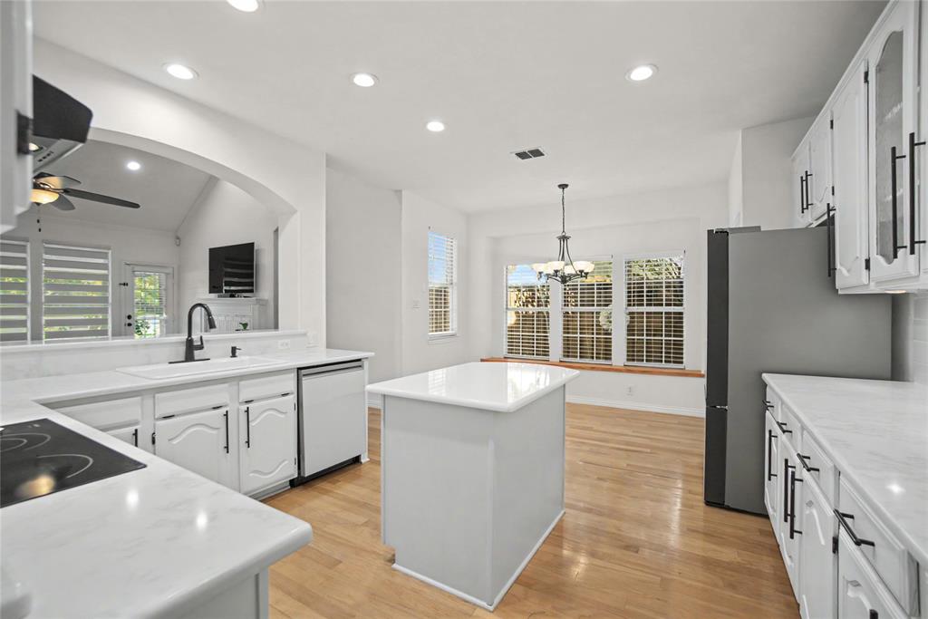 Installed designer quartz counter tops and white subway tile backsplashes. Soft white cabinetry with some glass displays,and Black iron hardware.