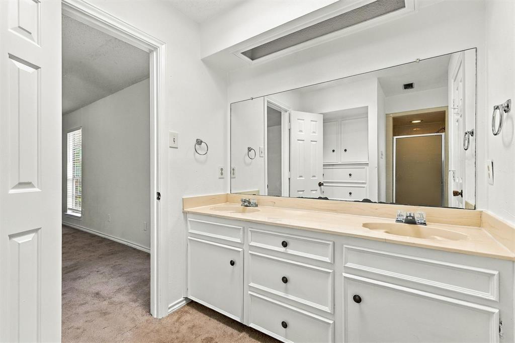 Dual-basin vanity featuring white cabinetry, integrated surface-mounted sinks, a full-width wall mirror, and recessed ceiling lighting