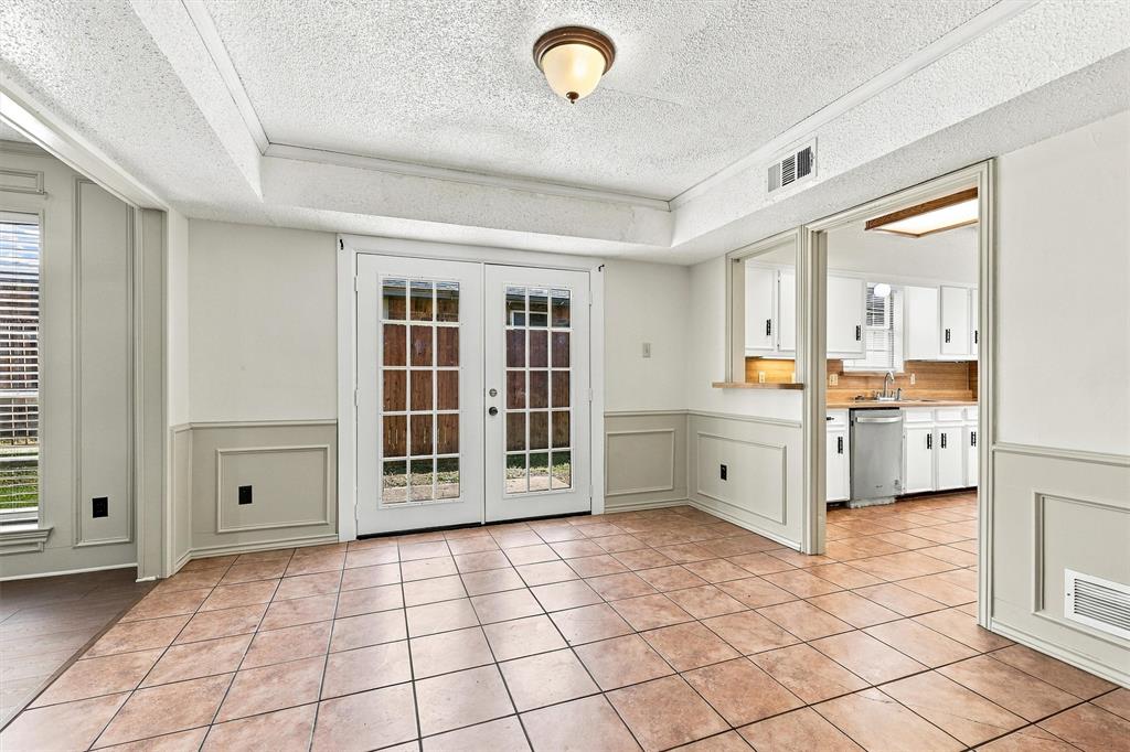 Ceramic tile flooring, full-lite French doors, wainscoting, and a kitchen pass-through window with built-in counter