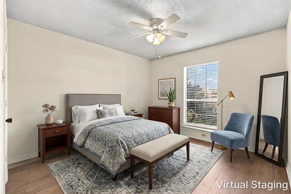 Wood-finish flooring, ceiling fan with integrated light fixture, and large window with horizontal blinds