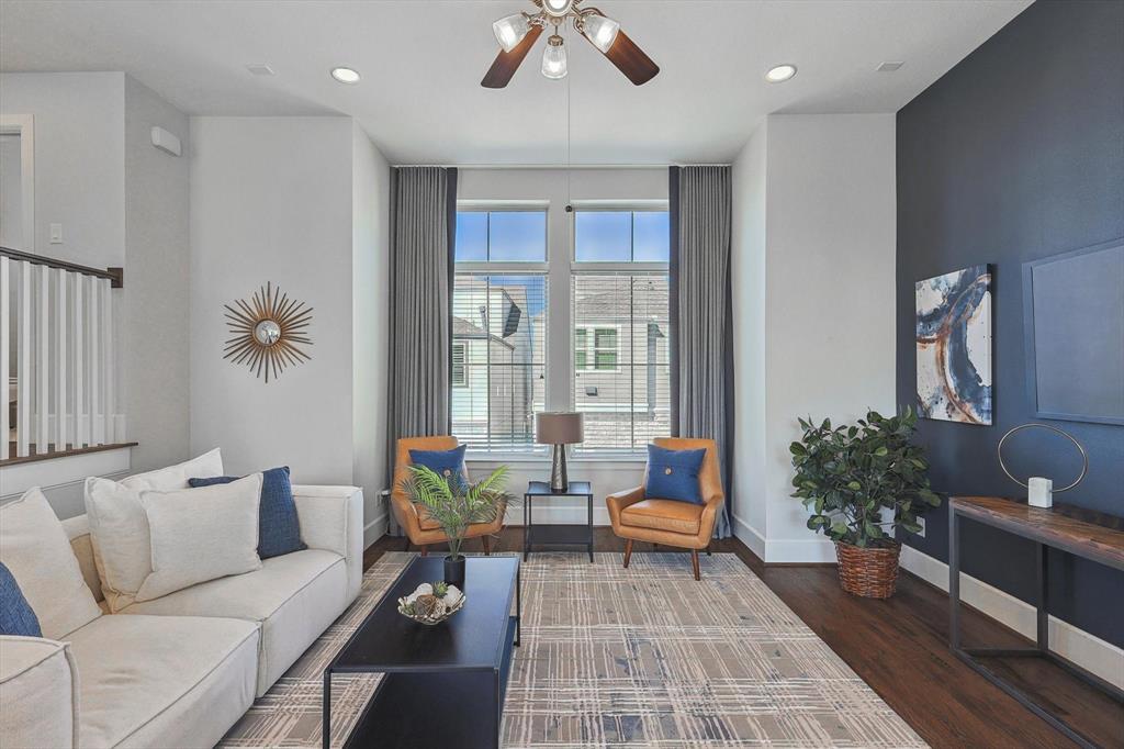 Living room with dark hardwood / wood-style floors and ceiling fan