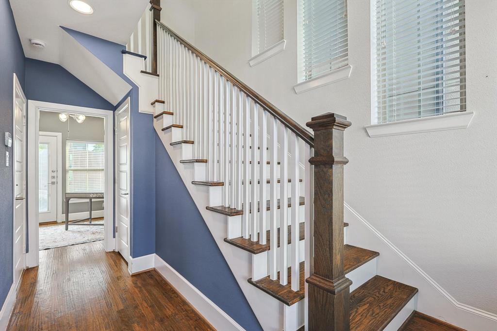 Stairway featuring hardwood / wood-style flooring and vaulted ceiling