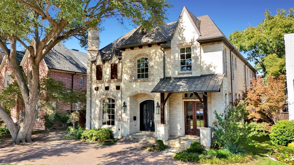Traditional stone exterior featuring a multi-gabled roofline, metal awning, arched entryway, and multi-pane windows Traditional stone exterior featuring a multi-gabled roofline, metal awning, arched entryway, and multi-pane windows