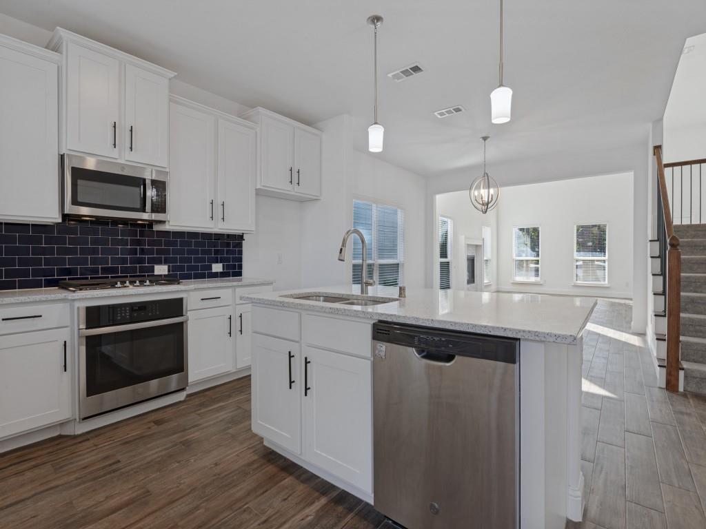 Spacious kitchen with generous cabinet storage, a contrasting tile backsplash, and an open layout.