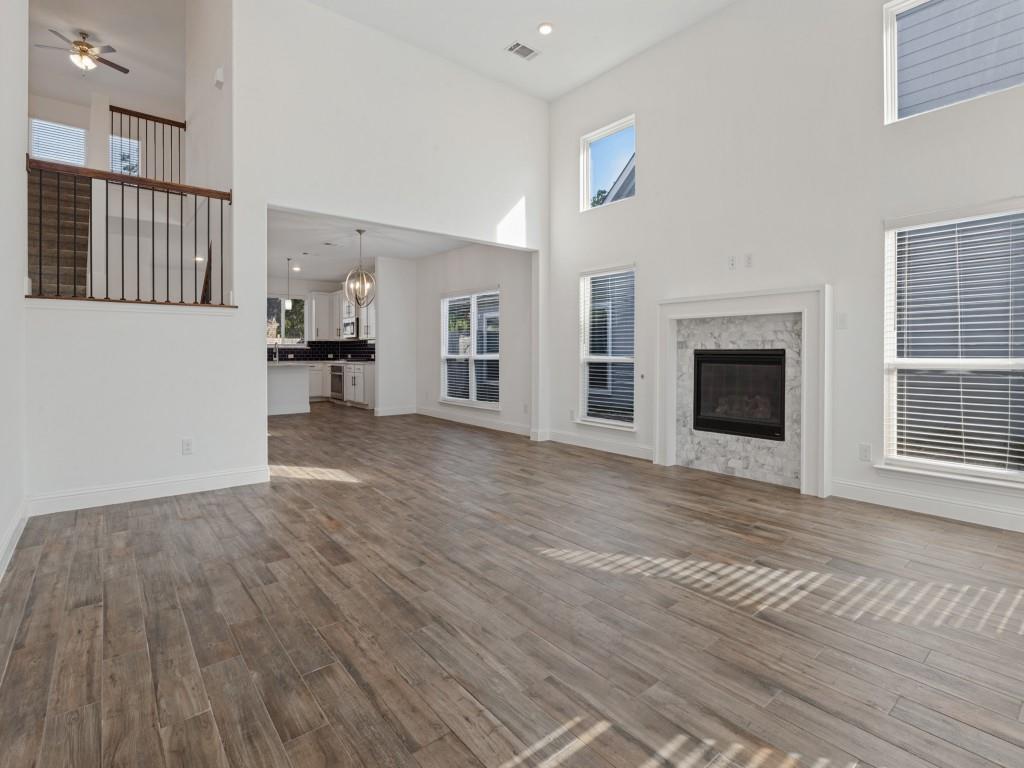 Open living area with wood-look tile flooring and views of the upstairs loft Open living area with wood-look tile flooring and views of the upstairs loft