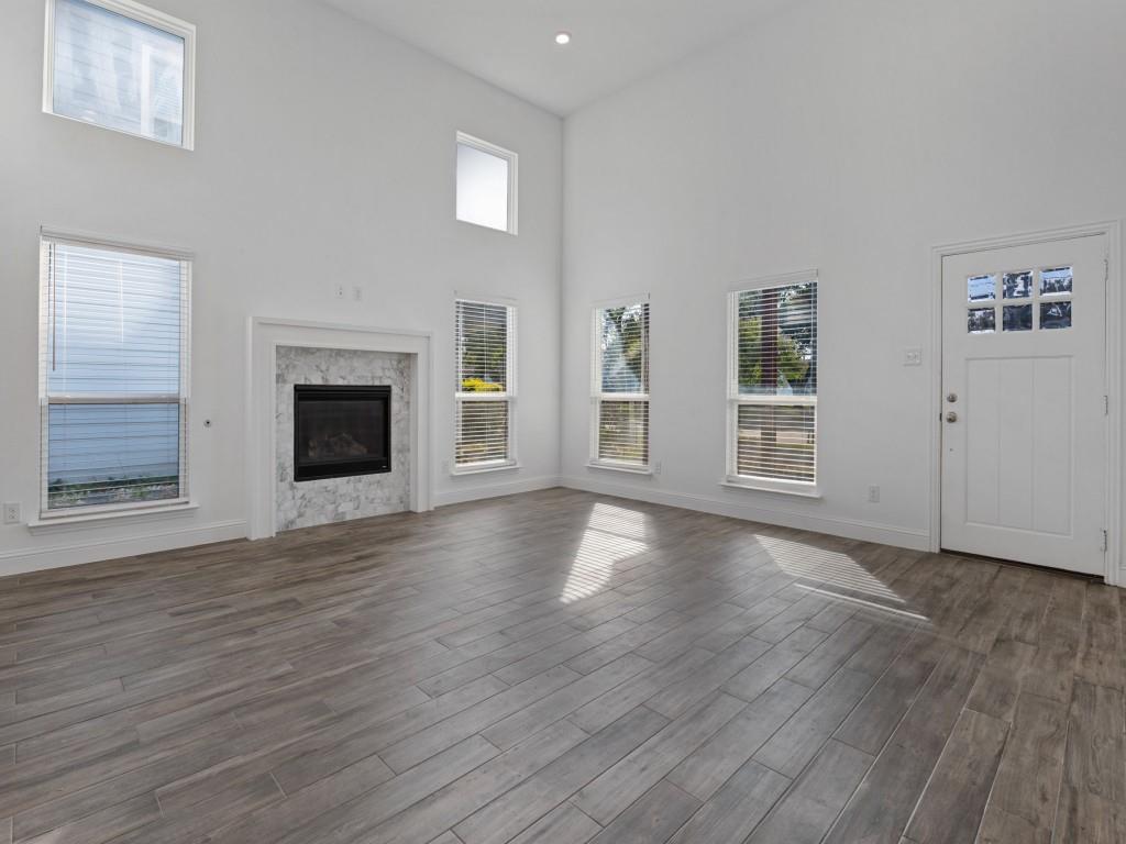 Soaring ceilings, abundant natural light, and a welcoming fireplace highlight the spacious living room Soaring ceilings, abundant natural light, and a welcoming fireplace highlight the spacious living room