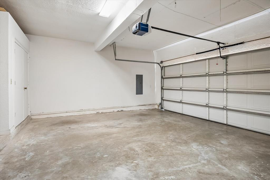 Multi-car garage featuring a sectional overhead door, concrete flooring, and an integrated garage door opener