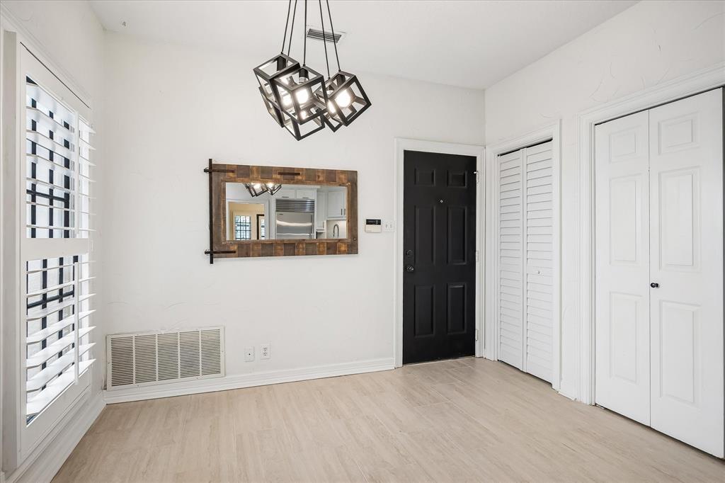 Geometric multi-light pendant fixture, white plantation shutters, wood-finish flooring, and crisp white panel doors