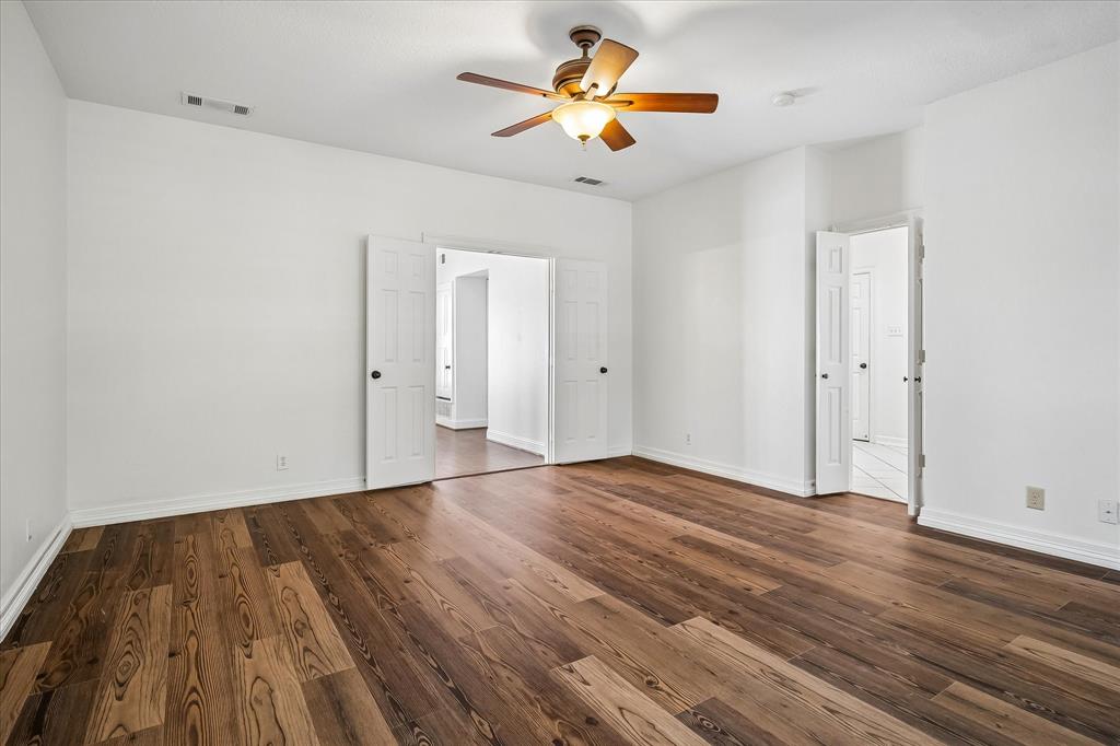 Interior space featuring VLP flooring, white walls, double-door entryway, and a ceiling fan with integrated light fixture