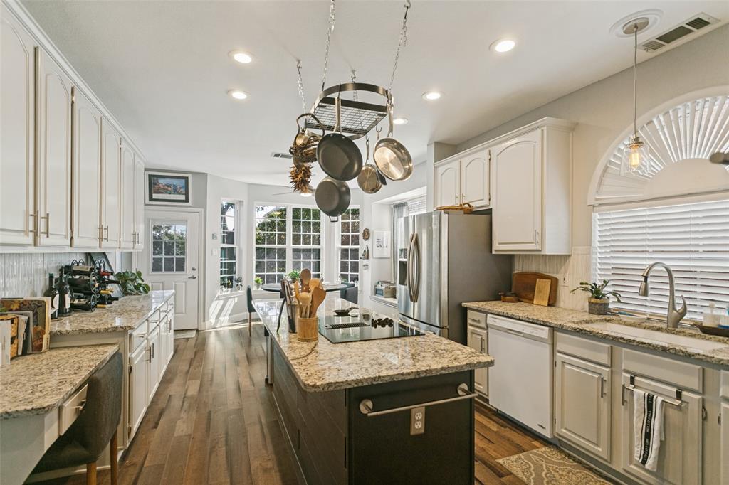 Kitchen featuring white shaker-style cabinetry, stone countertops, a center island with a built-in cooktop, recessed lighting, and wood-finish flooring