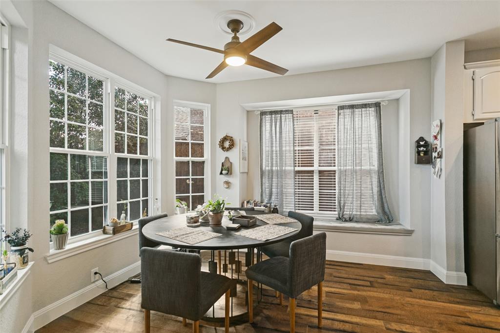 Multi-pane windows, wood-finish flooring, ceiling fan with integrated lighting, and a built-in window seat