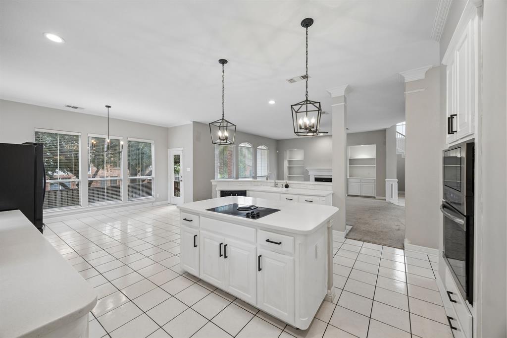 Kitchen featuring a center island with a built-in cooktop, white cabinetry, integrated double wall ovens, recessed lighting, and geometric-style pendant fixtures