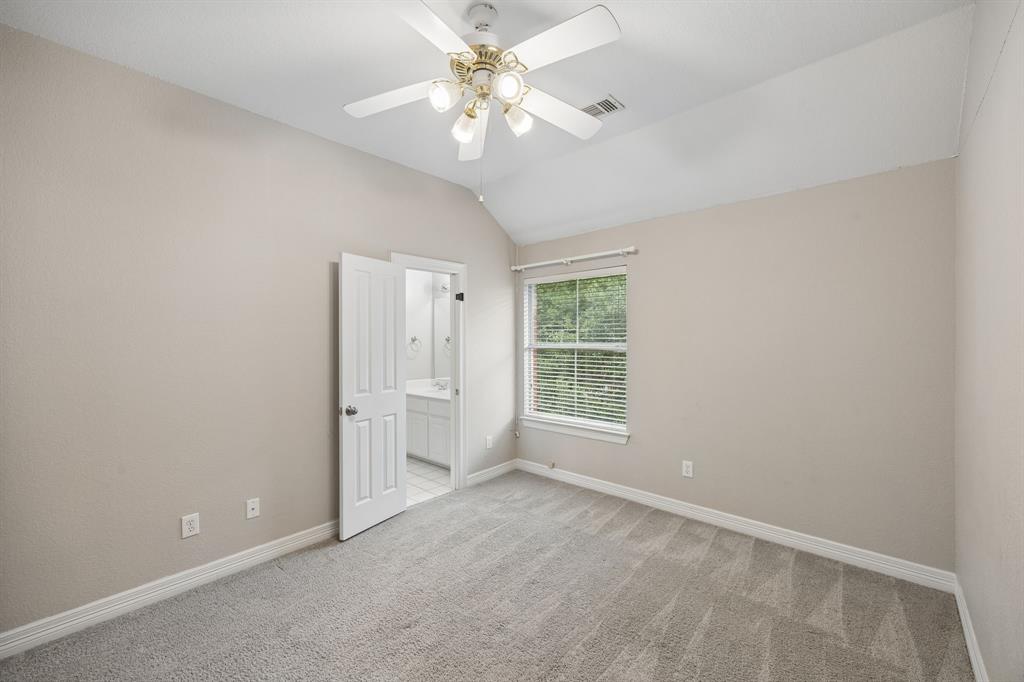 Vaulted ceilings, carpeted flooring, window with blinds, and a multi-light ceiling fan