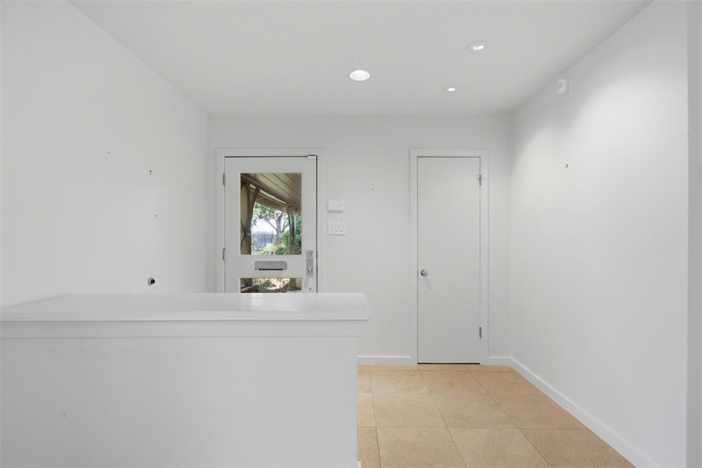 Entryway featuring neutral tile flooring, recessed ceiling lighting, a solid-core interior door, and an exterior door with a glass pane