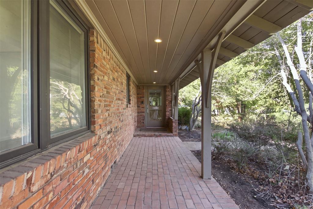Covered brick porch featuring recessed lighting, a brick floor, and wood-paneled ceiling