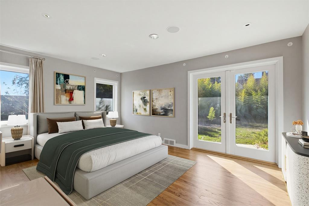 Room featuring wood-finish flooring, recessed lighting, double glass-panel doors, and multiple windows.