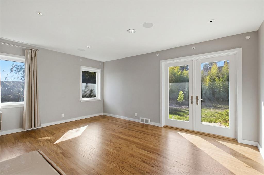 Interior space featuring wood-finish flooring, recessed lighting, double-paned windows, and glass-paneled double doors with metal hardware
