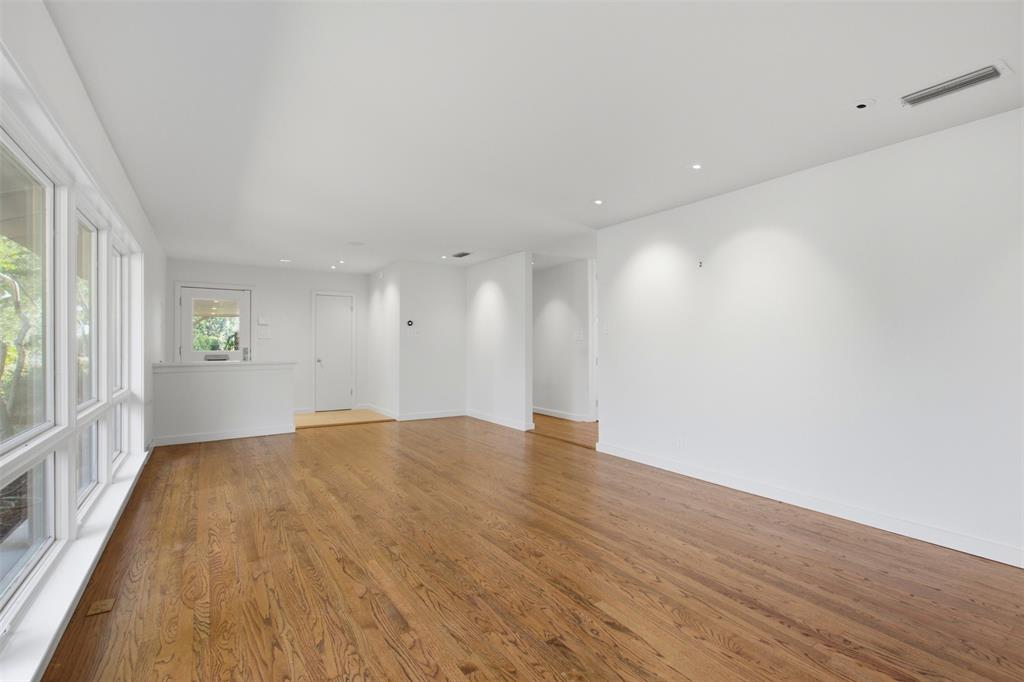 Open-concept interior featuring wood-finish flooring, recessed lighting, and large windows