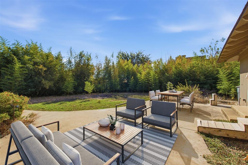 Concrete patio with a grassy lawn, mature perimeter trees. Concrete patio with a grassy lawn, mature perimeter trees.