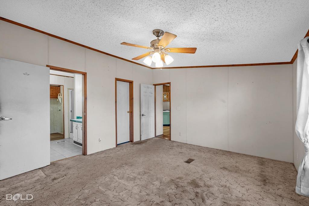 Interior space featuring carpeting, wood-trim detailing, and a multi-light ceiling fan