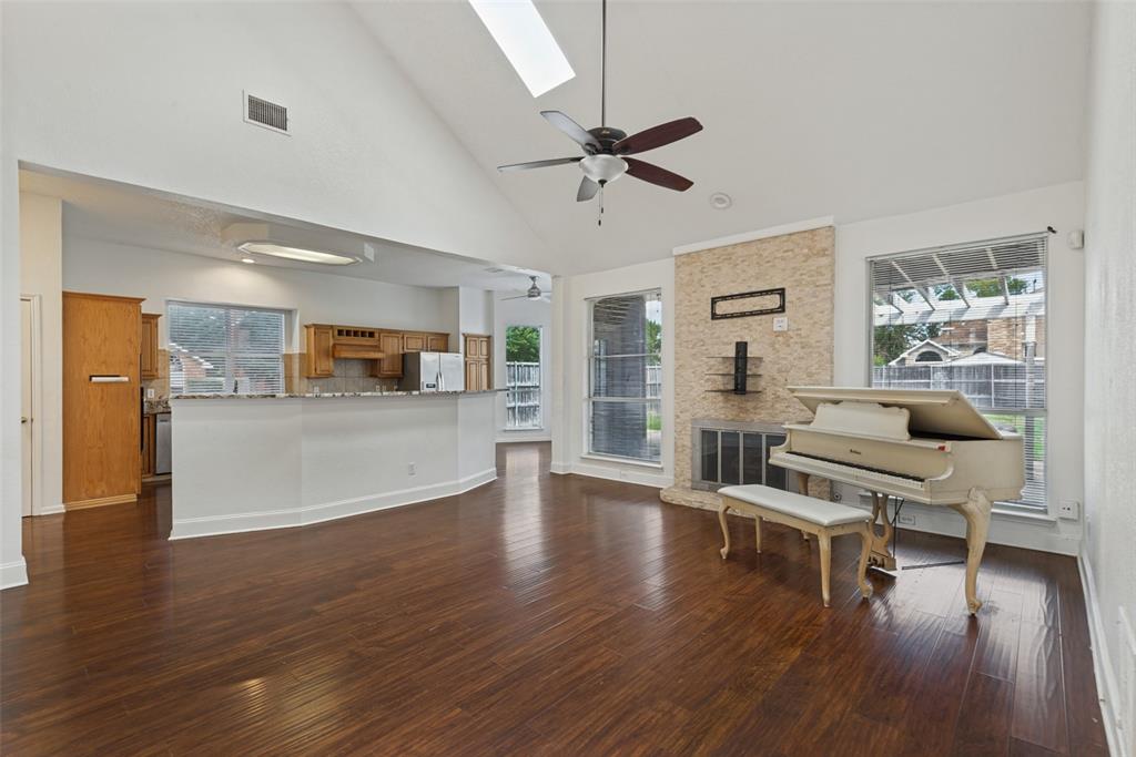 Vaulted ceilings with an integrated skylight, wood-finish flooring, a stone-surround fireplace, and an expansive breakfast bar Vaulted ceilings with an integrated skylight, wood-finish flooring, a stone-surround fireplace, and an expansive breakfast bar