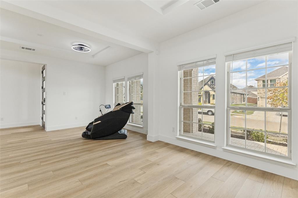 Spacious interior featuring wood-finish flooring, recessed lighting, expansive windows with grid detailing, and neutral wall tones