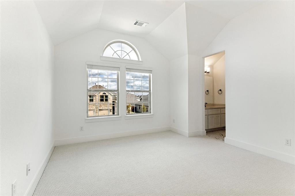 Vaulted ceilings, arched transom window, dual pane windows with integrated muntins, and neutral wall-to-wall carpeting