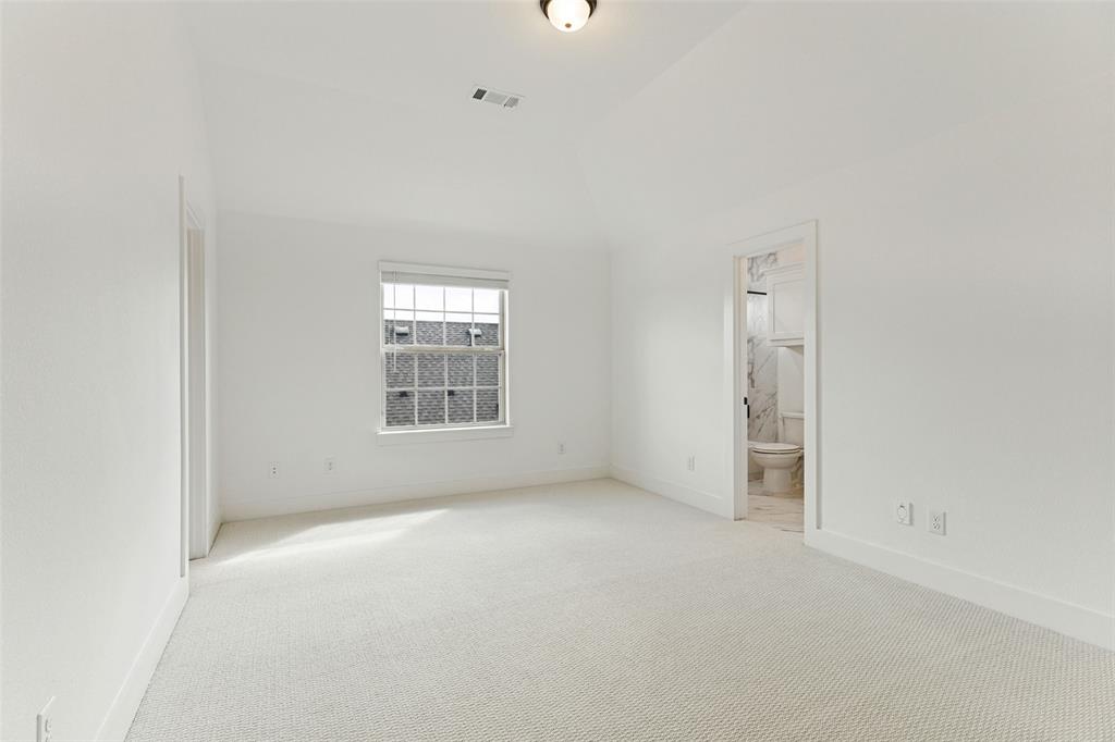 Vaulted ceilings, neutral carpeting, and a single-hung window with a blind