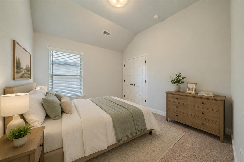 Vaulted ceiling, neutral wall color, carpeted flooring, and white double-door closet