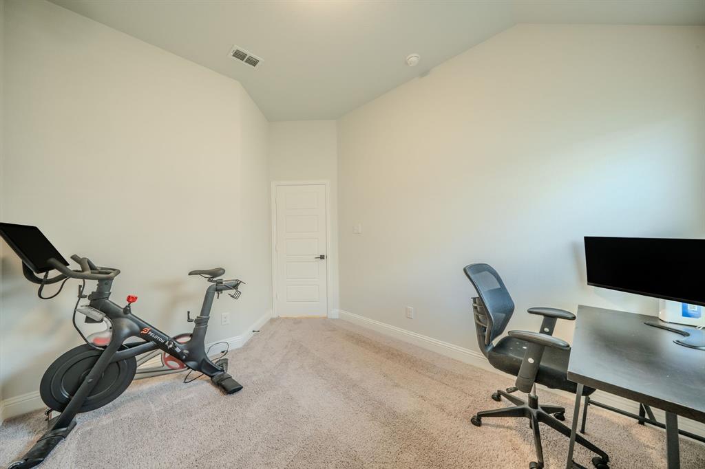 Vaulted ceiling featuring neutral wall paint, carpeting, and a four-panel interior door