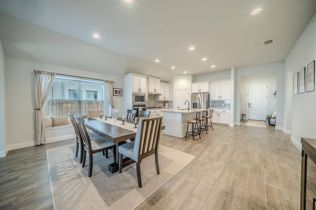Kitchen featuring white shaker cabinetry, a center island with quartz countertops, recessed lighting, and wood-finish flooring throughout