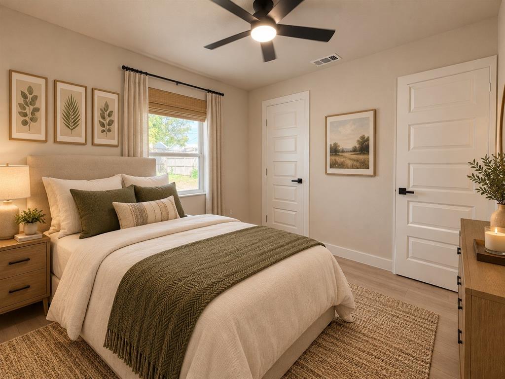 Neutral-toned interior featuring wood-finish flooring, a matte black ceiling fan with integrated lighting, and two five-panel interior doors with matte black hardware