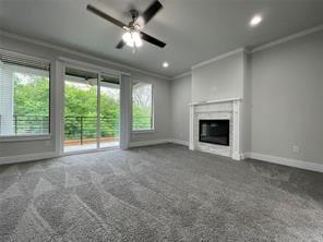 Fireplace with a classic white mantel, neutral carpeting, ceiling fan with integrated lighting, sliding glass doors, and recessed lighting