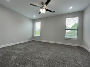 Neutral-toned interior featuring wall-to-wall carpeting, recessed lighting, a ceiling fan with integrated light fixture, and dual windows