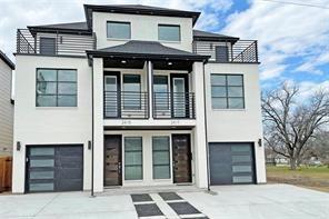 Three-story multi-unit exterior featuring smooth stucco siding, contemporary garage doors with horizontal glass panels, metal balcony railings, and multiple upper-level terraces