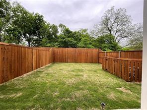 Backyard featuring a wood privacy fence, integrated wooden enclosure, and lawn area