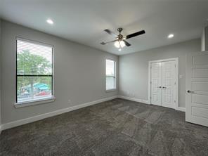 Neutral-toned interior featuring wall-to-wall carpeting, recessed lighting, a ceiling fan, and double panel doors