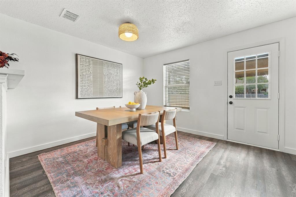 Wood-finish flooring, textured ceiling, cylindrical woven-shade flush mount lighting, single-pane window with horizontal blinds, and a white six-lite exterior door
