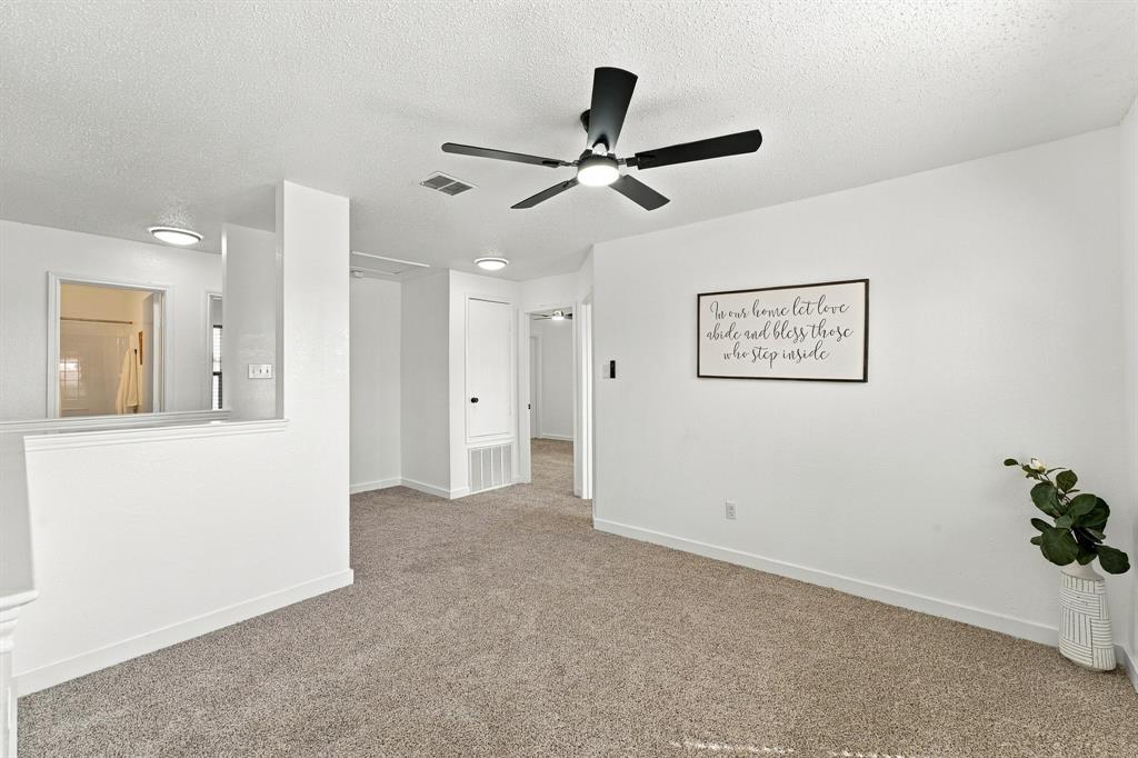 Neutral interior space featuring carpeted flooring, a ceiling fan with integrated lighting, and recessed overhead illumination