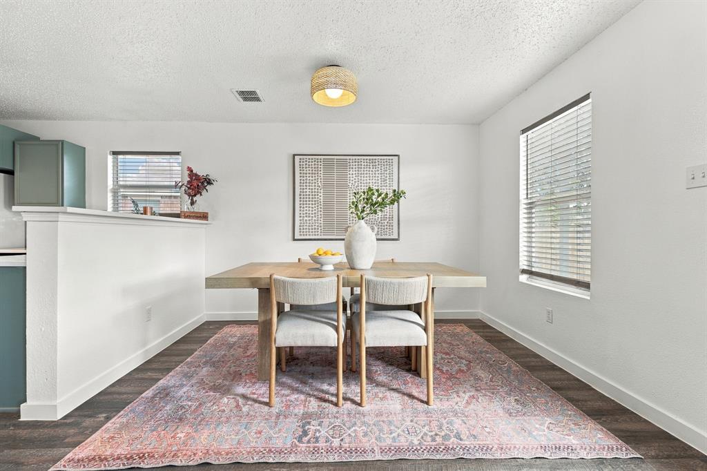 Neutral interior featuring wood-finish flooring, a textured drum-style ceiling light fixture, and horizontal window blinds