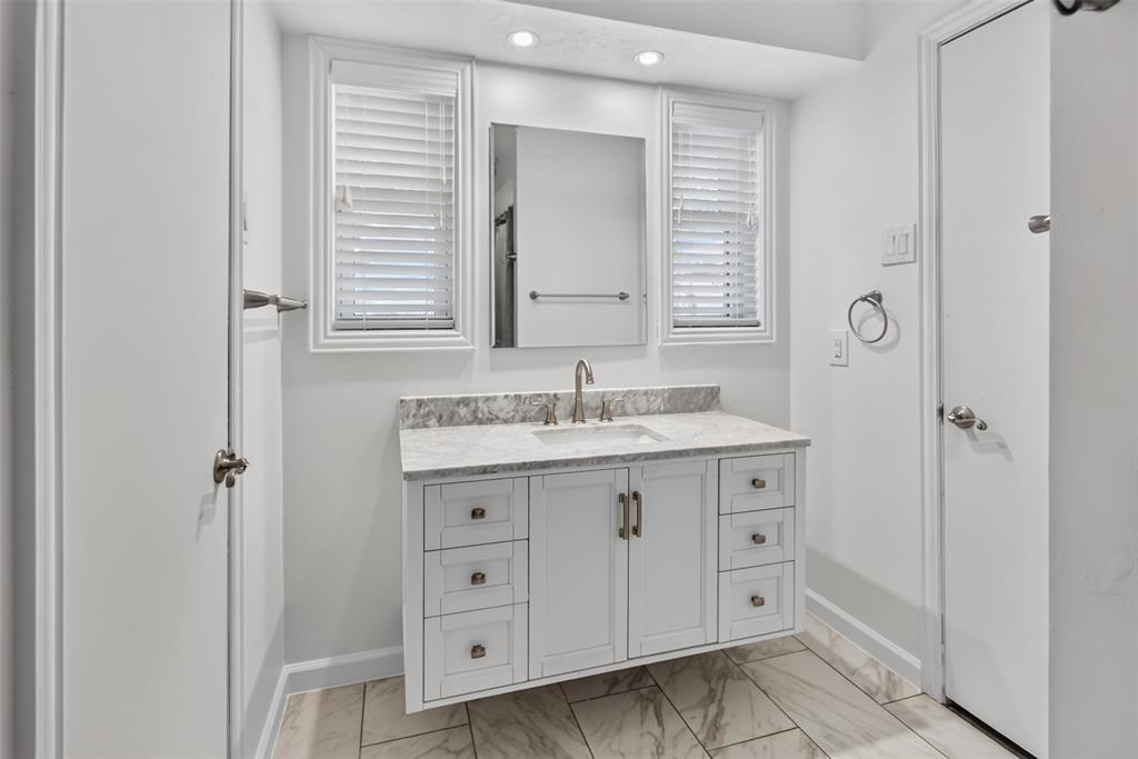 Jack N Jill bathroom between the two secondary bedrooms. Tile floor, updated sink and faucet and granite counter top.Recessed lights and lots of natural lights from 2 windows with blinds. August 2026 Wallpaper removed and walls resurfaced and freshly painted.