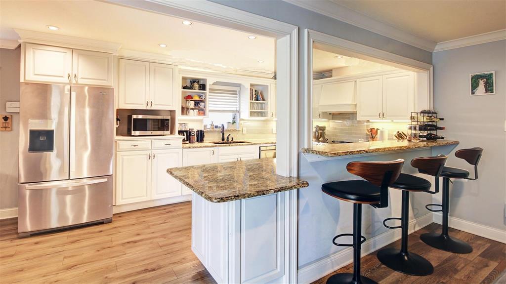 Love this kitchen with granite counter tops and subway tile backsplash, under and over counter lighting. Raised bar allows for additional seating. Lots of cabinets, 2 turnstyle cabinets and pullout drawers for ease of retrieving items. Recessed lighting, window over deep sinks & a super quiet dishwasher.