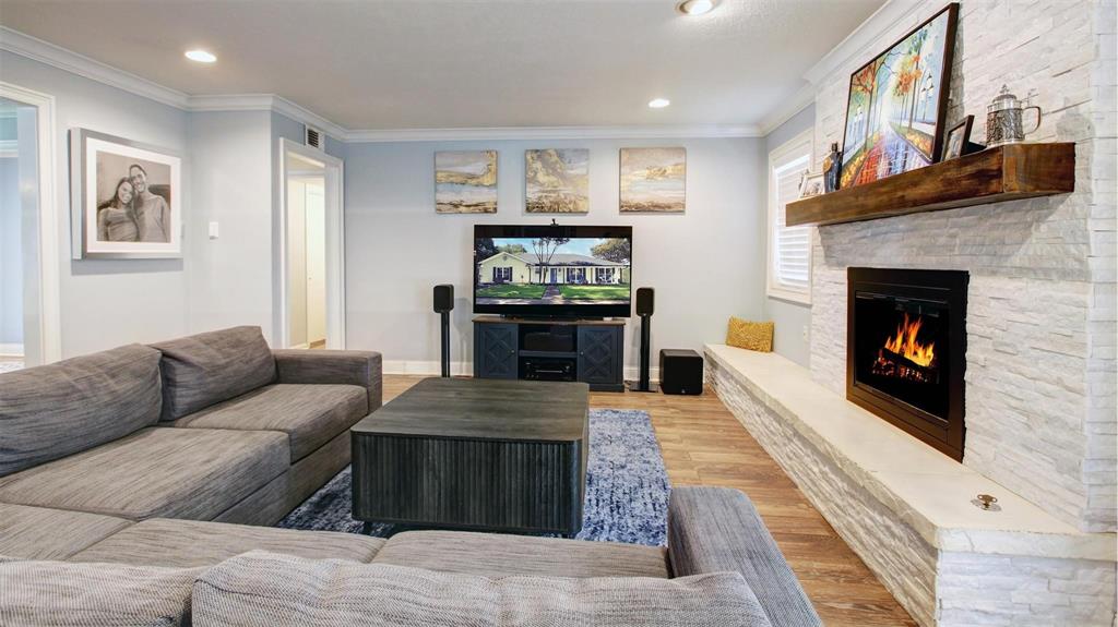 View of the living room from the Kitchen. Plenty of possibilities for furniture placement. Extended raised ledge from fireplace allows for additional seating, accent pieces or storage basket for your sofa throws.