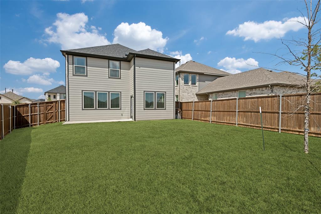 Private backyard featuring a manicured lawn, concrete patio, and full-height wood privacy fencing