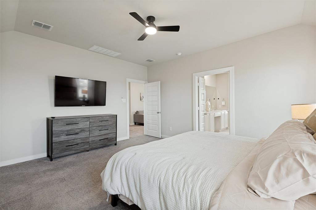 Vaulted ceilings with a central ceiling fan, neutral wall finishes, and solid-core interior doors Vaulted ceilings with a central ceiling fan, neutral wall finishes, and solid-core interior doors