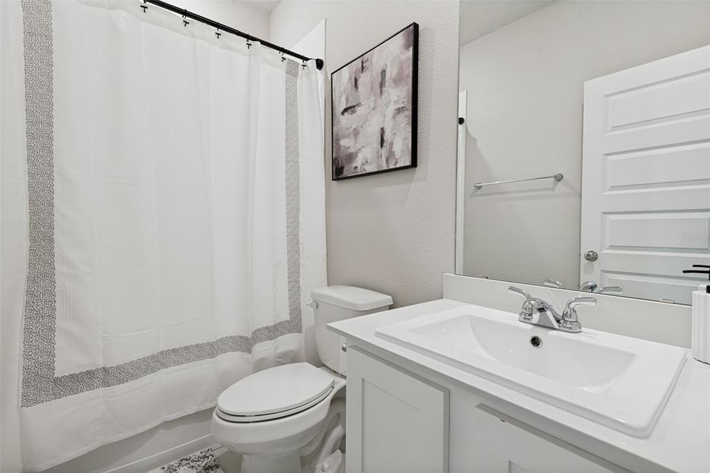 Bathroom featuring a white vanity with an integrated sink, polished chrome faucet, full-width mirror, and four-panel interior door
