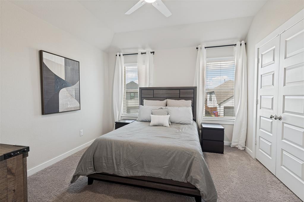 Vaulted ceiling, neutral wall tones, dual windows with horizontal blinds, and a white paneled closet door